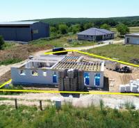 5-izbový dom 162m2 + pozemok 604m2 | Trenčianske Jastrabie - Stavba rodinného domu v Trenčianskom Jastrabí, obklopená zeleňou a ďalšími budovami.