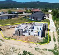 5-izbový dom 162m2 + pozemok 604m2 | Trenčianske Jastrabie - Stavba rodinného domu v Trenčianskom Jastrabí, obklopená vidieckou krajinou a susednými domami.