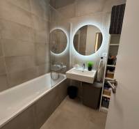 Nový 2-izbový byt na prenájom - Bory - Kúpeľňa s vaňou, umývadlom a osvetleným okrúhlym zrkadlom v 2-izbovom byte.