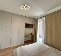 Nový 2-izbový byt na prenájom - Bory - Spálňa v 2-izbovom byte s podlahou s dreveným dekorom a vstavanou skriňou.