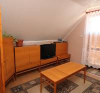 ZNÍŽENÁ cena - viacgeneračný  rodinný dom v Borinke  - Obývacia izba s dreveným nábytkom, gaučom a balkónom v rodinnom dome na ulici Borinka.