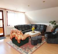 ZNÍŽENÁ cena - viacgeneračný  rodinný dom v Borinke  - Obývačka s tmavým sedením, konferenčným stolíkom a kvetinami v Rodinnom dome na ulici Borinka.