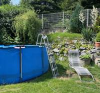 ZNÍŽENÁ cena - viacgeneračný  rodinný dom v Borinke  - Na záhrade rodinného domu pri ulici Borinka je bazén a lehátko na trávniku.