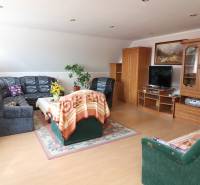 ZNÍŽENÁ cena - viacgeneračný  rodinný dom v Borinke  - Obývacia izba s dreveným nábytkom, televízorom, sedačkou, dekami; Borinka, rodinný dom.