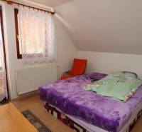 ZNÍŽENÁ cena - viacgeneračný  rodinný dom v Borinke  - Spálňa s purpurovou posteľou, oknom a závesmi na ulici Borinka, rodinne priateľský dom.