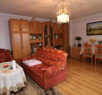 ZNÍŽENÁ cena - viacgeneračný  rodinný dom v Borinke  - Obývacia izba s oranžovým nábytkom, lustrom a dekoráciami, na ulici Borinka. Rodinný dom.