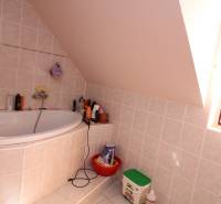 ZNÍŽENÁ cena - viacgeneračný  rodinný dom v Borinke  - Kúpeľňa s vaňou, šikmým stropom a umiestnenými čistiacimi potrebami. Dom na ulici Borinka.