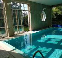 Predaj luxusná 5 izbová Vila,440 m2,pozemok 1061m2,garáž,bazén. - Interiér vily s krytým bazénom a presklenými stenami, ponúka výhľad do záhrady.