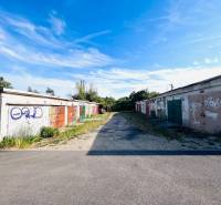 Ponúkame na prenájom Garáž na Skalickej ul. Nové Mesto - Garáže na Skalickej ceste, Bratislava - Nové Mesto, pokryté graffiti pod modrou oblohou.