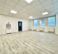 PRIESTORY, NA PRENÁJOM, CENTRUM TRENČÍN, ul. Jilemnického - Veľká kancelária s podlahou s dreveným dekorom a umývadlom.