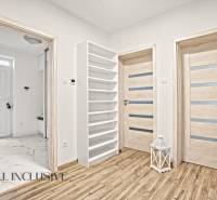 NA PREDAJ MODERNÝ 3-IZB. RD TYPU BUNGALOV V GABČÍKOVE - Interiér rodinného domu s podlahou s dreveným dekorom, dverami a bielym regálom.