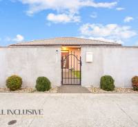 NA PREDAJ MODERNÝ 3-IZB. RD TYPU BUNGALOV V GABČÍKOVE - Rodinný dom v Gabčíkove s plotom, bránou a ozdobnými kríkmi.