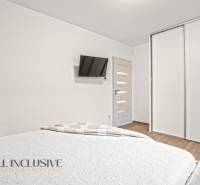 NA PREDAJ MODERNÝ 3-IZB. RD TYPU BUNGALOV V GABČÍKOVE - Spálňa v rodinnom dome s bielymi skriňami, TV na stene a podlahou s dreveným dekorom.