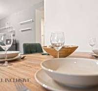 NA PREDAJ MODERNÝ 3-IZB. RD TYPU BUNGALOV V GABČÍKOVE - Jedálenský stôl s pohármi, taniermi a miskou v interiéri rodinného domu.