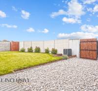 NA PREDAJ MODERNÝ 3-IZB. RD TYPU BUNGALOV V GABČÍKOVE - Záhrada pri rodinnom dome v Gabčíkove s trávnikom, kamienkami a dreveným plotom.