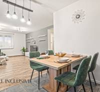 NA PREDAJ MODERNÝ 3-IZB. RD TYPU BUNGALOV V GABČÍKOVE - Interiér rodinného domu s podlahou s dreveným dekorom, jedálenský stôl a zelené stoličky.