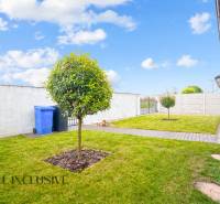 NA PREDAJ MODERNÝ 3-IZB. RD TYPU BUNGALOV V GABČÍKOVE - Záhrada rodinného domu v Gabčíkove s trávnikom, stromom a chodníkom vedľa plotu.