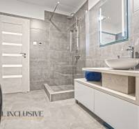 NA PREDAJ MODERNÝ 3-IZB. RD TYPU BUNGALOV V GABČÍKOVE - Kúpeľňa so sprchou, umývadlom na drevenej doske a práčkou v rodinnom dome.