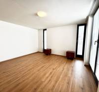 Na prenájom veľký 2- izb. byt na začiatku Koliby s terasou a wellness - Izba v 2-izbovom byte s drevenou podlahou, bielymi stenami a oknami.