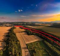 Rokycany – 38.000 m2 LESNÝ POZEMOK v podiele 1/1 - Poľnohospodárske a lesné pozemky v Rokycanoch pri západe slnka, s viditeľnou červenou čiarou.