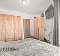 NA PREDAJ 2-IZBOVÝ BYT S 2 BALKÓNMI, DUNAJSKÁ STREDA - Spálňa v 2-izbovom byte s podlahou s dreveným dekorom a šatníkovými skriňami.