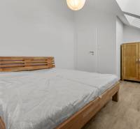 OPAL - NOVÝ a KOMPLETNE ZARIADENÝ 2,5-izbový byt s LODŽIOU a PARKOVANÍ - Spálňa so svetlou posteľou a skriňou v 2-izbovom byte, podlaha s dreveným dekorom.