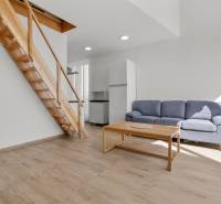 OPAL - NOVÝ a KOMPLETNE ZARIADENÝ 2,5-izbový byt s LODŽIOU a PARKOVANÍ - Obývacia izba v 2-izbovom byte s podlahou s dreveným dekorom, schodmi a šedou sedačkou.