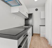 OPAL - NOVÝ a KOMPLETNE ZARIADENÝ 2,5-izbový byt s LODŽIOU a PARKOVANÍ - Svetlá kuchyňa s podlahou s dreveným dekorom v 2-izbovom byte, vybavená spotrebičmi.