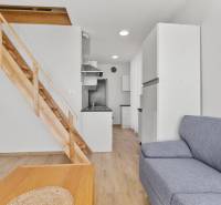 OPAL - NOVÝ a KOMPLETNE ZARIADENÝ 2,5-izbový byt s LODŽIOU a PARKOVANÍ - Obývacia izba v 2-izbovom byte s gaučom, dreveným schodiskom a kuchyňou.