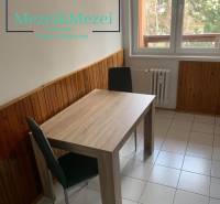 Na predaj prakticky riešený 2-izbový byt s balkónom - Jedálenský kút v 2-izbovom byte s dreveným dekorom na stenách a dlažbou.