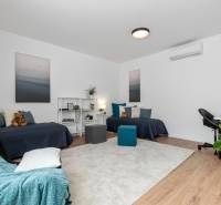 BÝVANIE VO VILA DOME - POSLEDNÝ VOĽNÝ 3-IZBOVÝ BYT SO ZÁHRADOU - Izba v 3-izbovom byte so svetlým kobercom, posteľami a pracovným stolom.