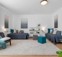 BÝVANIE VO VILA DOME - POSLEDNÝ VOĽNÝ 3-IZBOVÝ BYT SO ZÁHRADOU - Obývacia izba s dvomi posteľami, podlaha s dreveným dekorom, koberec, dekorácie a nábytok.