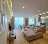 REZERVOVANÉ - 3i, OV, 71m2 + loggia, Lomonosovova, dizajnový, zariaden - Obývačka v 3-izbovom byte s pohovkou, podlahou s dreveným dekorom a moderným osvetlením.