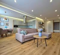 REZERVOVANÉ - 3i, OV, 71m2 + loggia, Lomonosovova, dizajnový, zariaden - Obývacia izba s podlahou s dreveným dekorom, sedacou súpravou a jedálenským stolom v 3-izbovom byte.