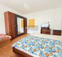 Prenájom, penzión Podhájska - EXKLUZÍVNE HALO REALITY - Izba s posteľou, skriňou, televízorom a podlahou s dreveným dekorom, typická pre hotely a penzióny.