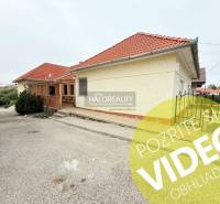 Prenájom, penzión Podhájska - EXKLUZÍVNE HALO REALITY - Exteriér Hotela a penziónu v Podhájskej s terasou, červenou strechou a zelenými kríkmi.