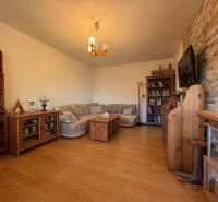 - PREDAJ - 2 izbový byt - Astrová ul. - Ružinov - Obývacia izba s pohovkou, podlaha s dreveným dekorom, knižnica a televízor na stene.