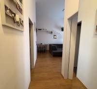 Prenájom moderného 2-izbového bytu v centre Komárna, 40 m² – Petőfiho  - Chodba v 2-izbovom byte s podlahou s dreveným dekorom a dekoráciami na stenách.