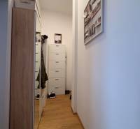 Prenájom moderného 2-izbového bytu v centre Komárna, 40 m² – Petőfiho  - Úzka chodba v 2-izbovom byte s podlahou s dreveným dekorom a šatníkom.