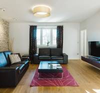 PREDAJ  kompletne prerobený 3 izbový rodinný dom, Nitra - centrum - Obývačka s koženou sedačkou, tehlovou stenou a podlahou s dreveným dekorom v rodinnom dome.