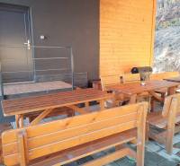 NOVOSTAVBA: 6-izbová CHATA, VL pozemok 484 m2 v Martine  - Chata na Stráňach v Martine s drevenými lavicami a grilom na terase.