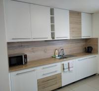 NOVOSTAVBA: 6-izbová CHATA, VL pozemok 484 m2 v Martine  - Kuchyňa na chate s bielymi skrinkami a podlahou s dreveným dekorom.