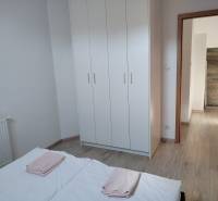 NOVOSTAVBA: 6-izbová CHATA, VL pozemok 484 m2 v Martine  - Spálňa v chate s bielou šatníkovou skriňou a podlahou s dreveným dekorom.