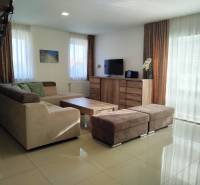 NOVOSTAVBA: 6-izbová CHATA, VL pozemok 484 m2 v Martine  - Obývacia izba v chate s pohovkou, televízorom a podlahou s dreveným dekorom.