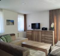 NOVOSTAVBA: 6-izbová CHATA, VL pozemok 484 m2 v Martine  - Svetlá izba v chate s pohodlnou sedačkou a podlahou s dreveným dekorom.