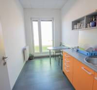 Na prenájom kancelária  15 m²,  v novostavbe, Odborárska ulica, voľná - Kuchynka v kancelárii s oranžovými skrinkami, drezom a stolíkom na sedenie.
