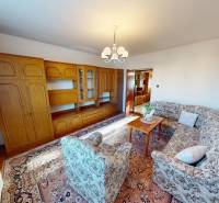 Rodinný dom v obci Bojná - Obývacia izba v rodinnom dome s drevenou obývacou stenou a vzorovanou sedacou súpravou.