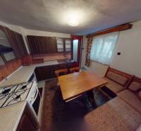 Rodinný dom v obci Bojná - Kuchyňa v rodinnom dome s drevenými skrinkami, sporákom a jedálenským stolom.