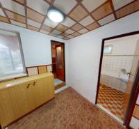 Rodinný dom v obci Bojná - Interiér v rodinnom dome s podlahou s dreveným dekorom, skrinkou a vstupom do kúpeľne.