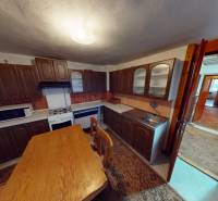 Rodinný dom v obci Bojná - Kuchyňa v rodinnom dome s dreveným nábytkom, stolom a spotrebičmi.